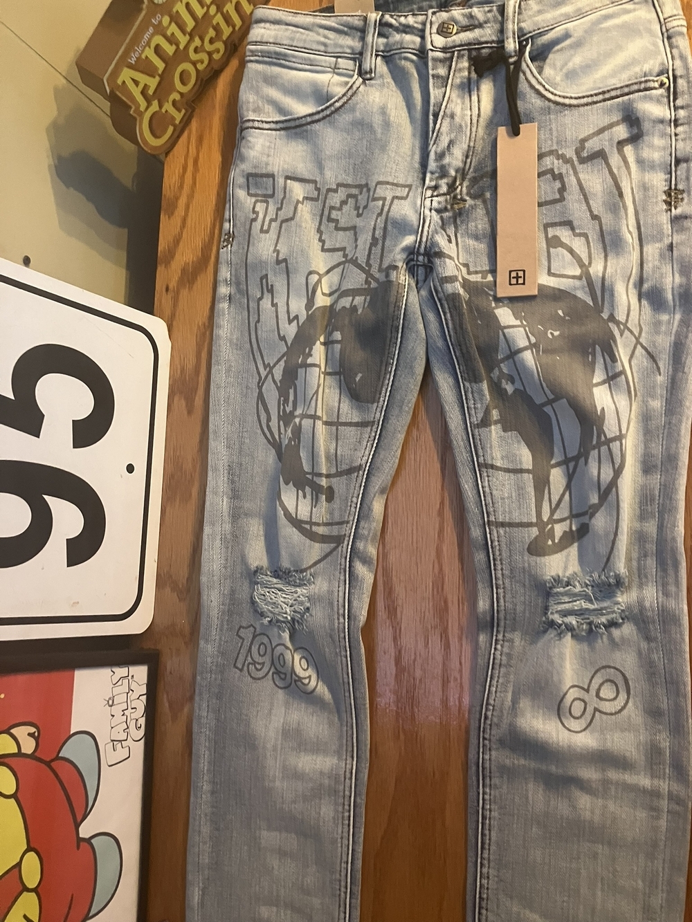 Blue distressed men’s Ksubi jeans with globe graffiti print